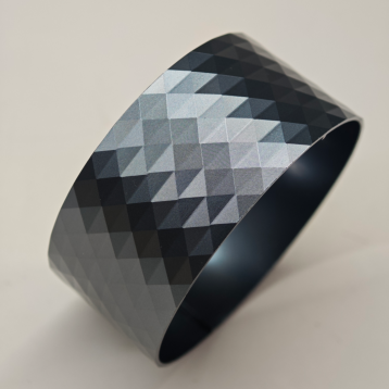CNC turned part with engraved geometric pattern